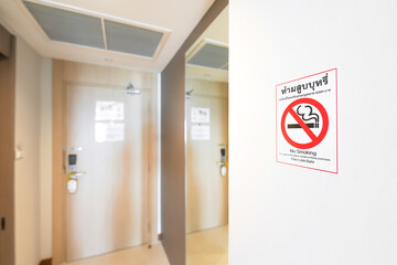 No smoking Sticker on wall beside toilet and exit door. Thai Letter on Sticker means, No Smoking....