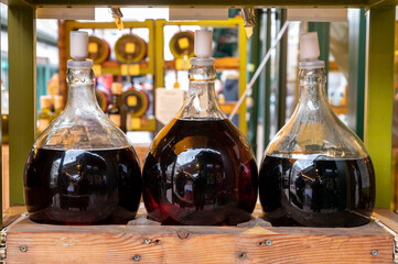 Big bottles with white and red wine Austrian vinegar made from local grapes on market in Vienna, Austria