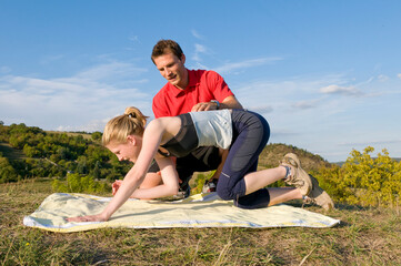 Frau trainiert mit Personal Trainer im Freien