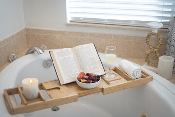 Bamboo bath caddy tray with book, candle and fruit