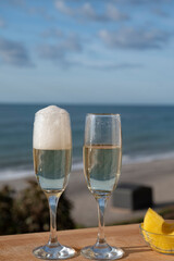 Outdoor breakfast with Spanish cava sparkling wine and pineapple with view on blue sea and sandy beach in Marbella, Costa del Sol vacation destination, Andalusia, Spain