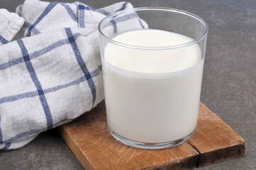 Verre de lait sur une planche à découper à côté d'un torchon en gros plan