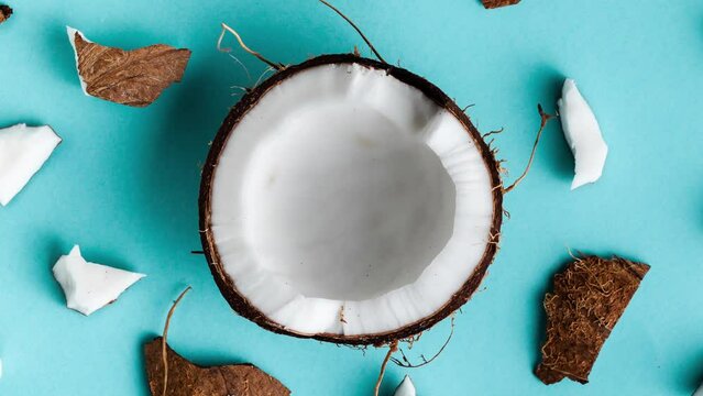 Cracked coconut with pieces on the blue (turquoise) background. 