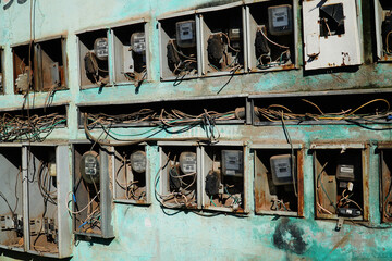 Fototapeta na wymiar Old electricity meters in a small village in Amazonas, Brazil. Electrical counters in use for different houses on a turquoise green wall, Cacau Pirera, Manaus, Brazil