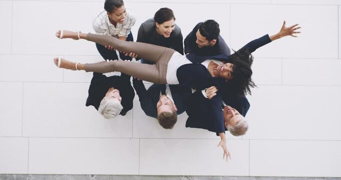 She does our team proud. 4k footage of a group of businesspeople throwing their colleague into mid air in celebration of her success.