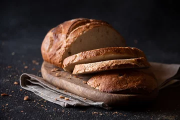 Printed kitchen splashbacks Bread Loaf of bread freshly baked and cut on dark background