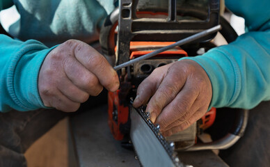 selective focus on a man's hands and an old electric saw. Man restores and sharpens the blades of an electric saw