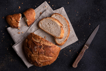 Loaf of bread freshly baked and cut on dark background