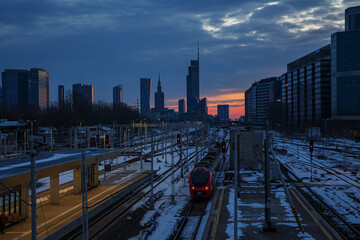Public transportation in Warsaw, Poland. City skyline and railroad station.