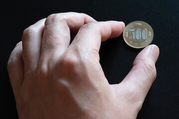 New 500 yen coin and hand