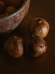 Still life with three ripe pomegranates on a wooden table 