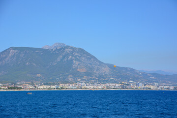 Fototapeta premium mediterranean sea with clear sky and parachute on mountains background