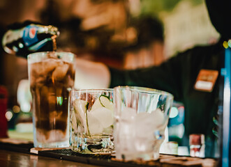 bartender with black gloves making cocktail on a bar counter.