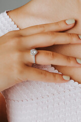 Close-up of an elegant engagement diamond ring on beautiful woman's finger. love and wedding concept. Like the split tone Instragram process.