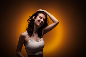 Teenage girl with dental braces. Studio portrait on neon orange colored background..