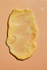 Smear of yellow cream in yellow background. Beauty creme smear swatch. Cream, Lotion for face or body.