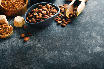 Coffee beans background. Roasted Coffee concept with differents types of coffee, beans and cinnamon sticks on dark black stone background. Top view. Coffee concept. Mock up.