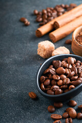Coffee beans background. Roasted Coffee concept with differents types of coffee, beans and cinnamon sticks on dark black stone background. Top view. Coffee concept. Mock up.