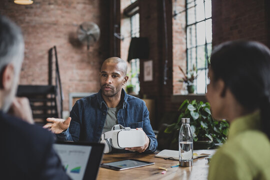 African American male game designer leading a meeting