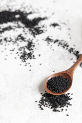 Wooden spoon of Indian spice Black cumin (nigella sativa or kalonji) seeds close up