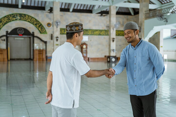 portraito of asian muslim people shaking hand at the mosque