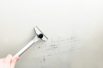 Construction scraper on gray wall background. Construction finishing works. Wall repair inside the...