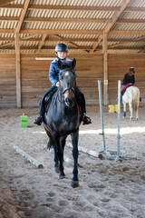 pretty girl on her pony during a riding lesson - 500256258