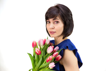 Portrait of a brunette woman with a bouquet of beautiful bright pink tulips white background.