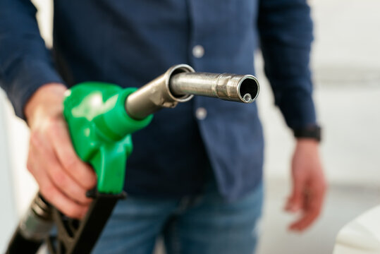 Anonymous man refilling vehicle tank at petrol station