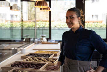 Beautiful smiling woman showing some trays with typical Italian fresh pasta - Young middle eastern...