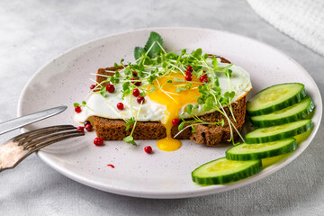Sandwich with scrambled eggs, microgreens and pink pepper on a plate. Delicious and healthy snack