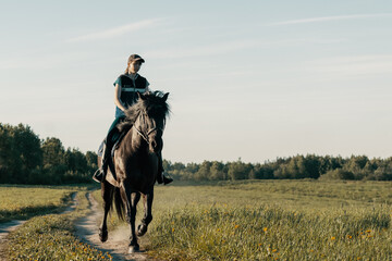Teenage girl riding horse on country road.
