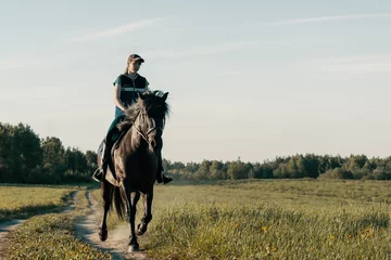 Fotobehang Teenage girl riding horse on country road. © Ирина Орлова