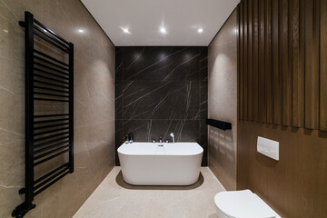Modern bathroom design. White bath on a black wall. Loft Style