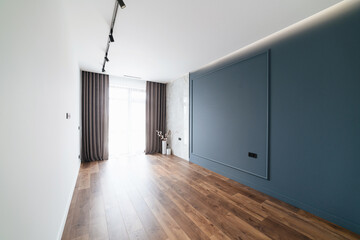 Modern interior design of a room with a large window and a blue wall