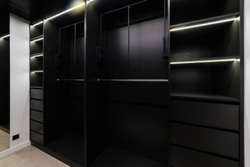 Dressing room with black furniture and lighting