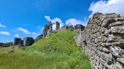 Fototapeta na wymiar Corfe Castle with blue sky and wall