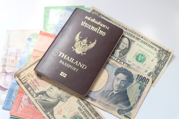 Thailand passport on mixed currency banknotes,inflation, currency concept.