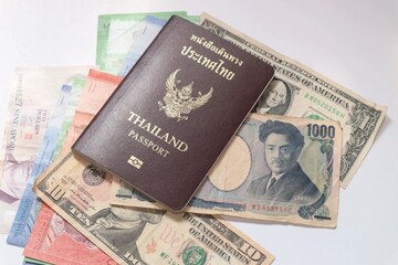 Thailand passport on mixed currency banknotes,inflation, currency concept.