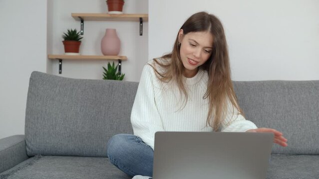 A young girl looks at a laptop screen to check something and then emotionally celebrates her success. The concept of winning or receiving the cherished.
