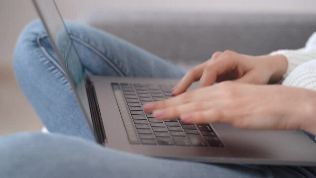 Close-up of a young girl's hands typing on a laptop keyboard. The concept of remote work or writer.