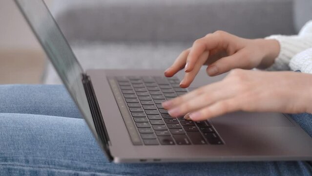 Close-up of a young girl's hands typing on a laptop keyboard. The concept of remote work or writer.