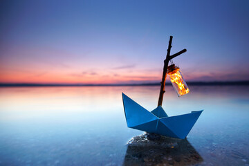 magical blue paper boat with lantern at the beach - romantic evening