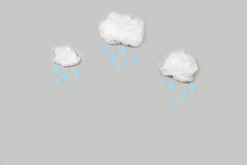 Nubes de algodón con gotas de lluvia sobre un fondo de cielo gris liso y aislado. Vista superior y de cerca. Copy space. Concepto: Meteorología