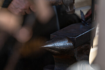 Selective focus of a blacksmith's metal anvil in a dark room, old professions, handmade. Soft...