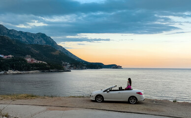 Stylish girl posing in a classic convertible