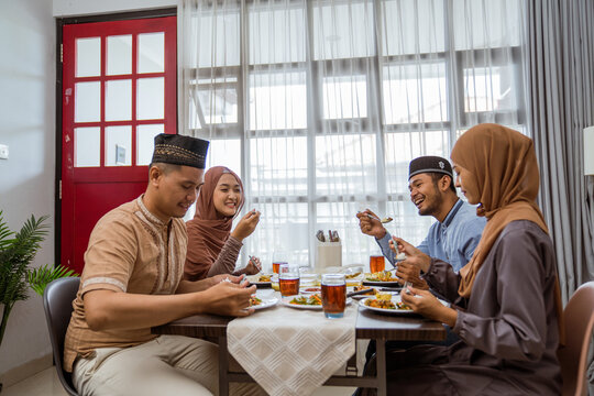 asian muslim friend and family break fasting together in dining room