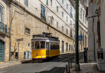 Plakat A typical vintage style public transport tram on the winding tracks in a street in Lisbon, Portugal.