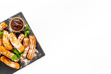 Churros with powdered sugar and chocolate sauce. Fast food sweets