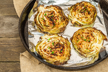 Homemade vegan cabbage steaks with herbs and spices. Healthy food ready to eat on a baking sheet